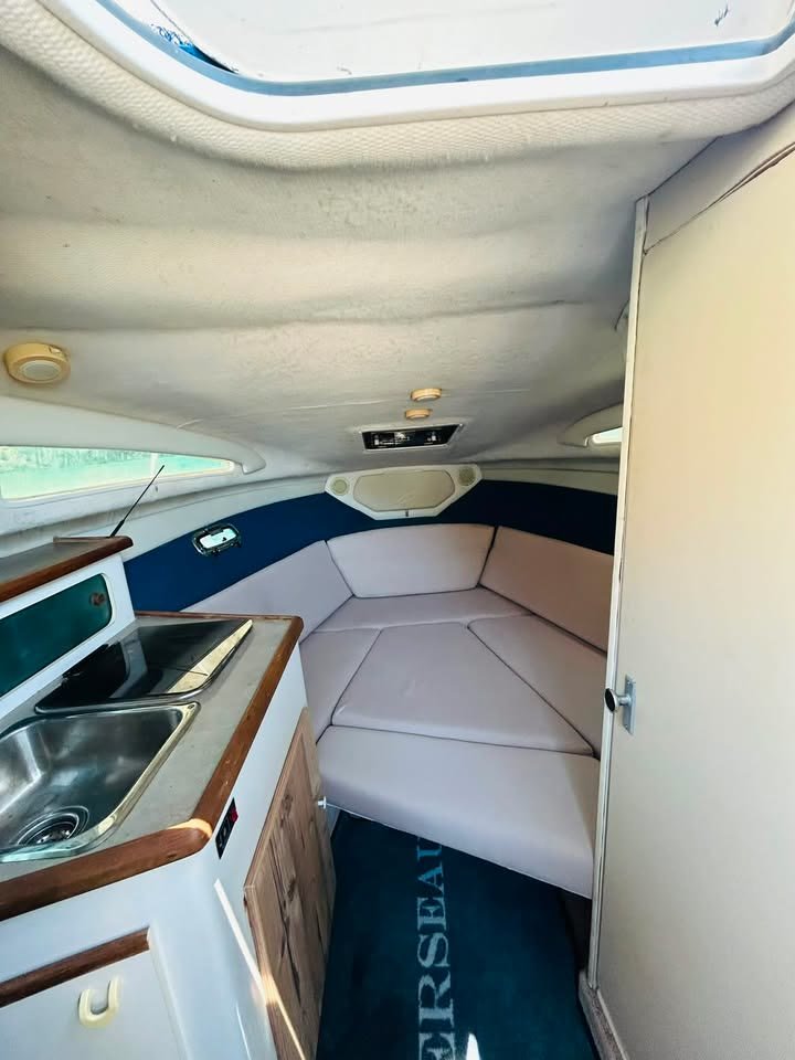 Second view into the cabin of ΝΙΚΟΛΑΟΣ, with the deck hatch open above the V-berth and daylight falling on the cushions